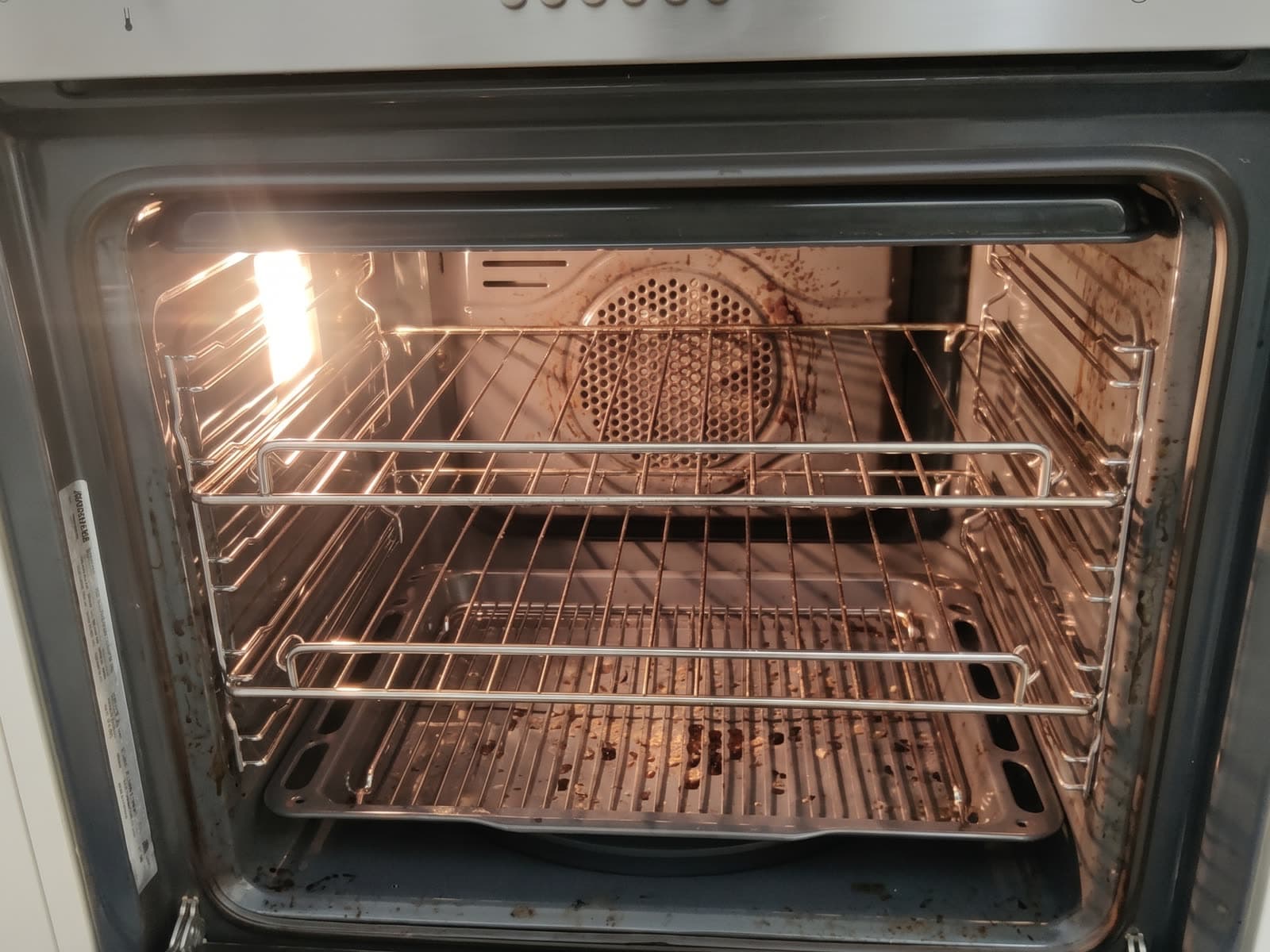 Oven interior with burnt-on grease on the racks, tray and walls before cleaning